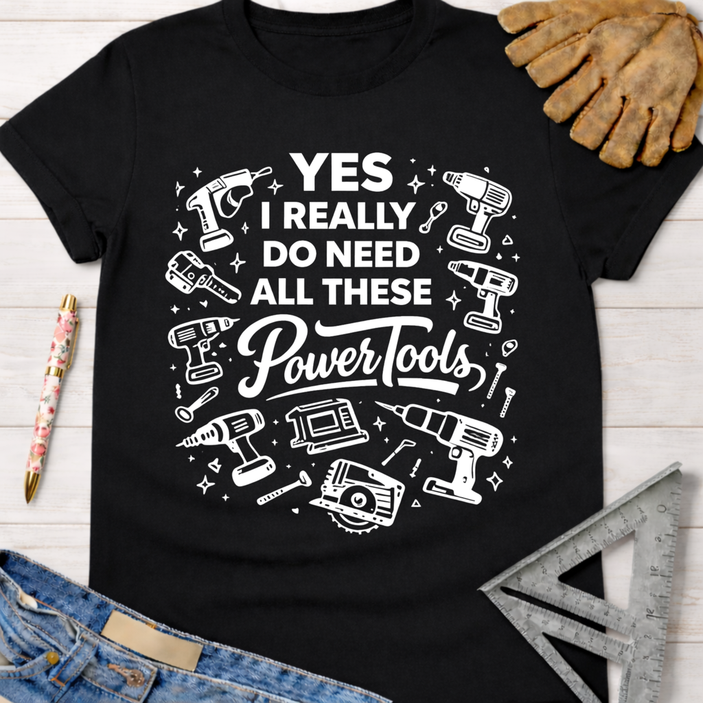 Women's funny woodworking graphic tee shirt for female woodworkers, makers, and DIY builders — Sawdust & Ponytails. Black cotton tee with "YES I REALLY DO NEED ALL THESE Power Tools" and various white tool graphics.