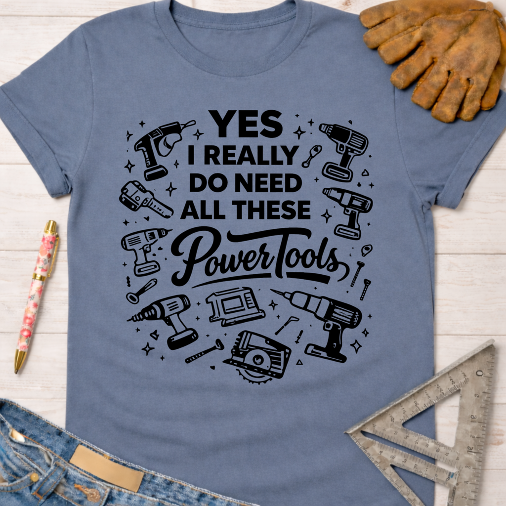 Women's funny woodworking graphic tee shirt for female woodworkers, makers, and DIY builders — Sawdust & Ponytails. Blue cotton tee with "YES I REALLY DO NEED ALL THESE Power Tools" and tool illustrations.