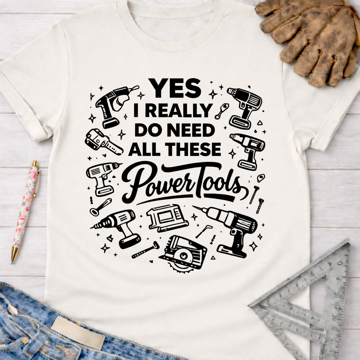 Women's funny woodworking graphic tee shirt for female woodworkers, makers, and DIY builders — Sawdust & Ponytails. White cotton t-shirt with "YES I REALLY DO NEED ALL THESE Power Tools" and black power tool graphics.