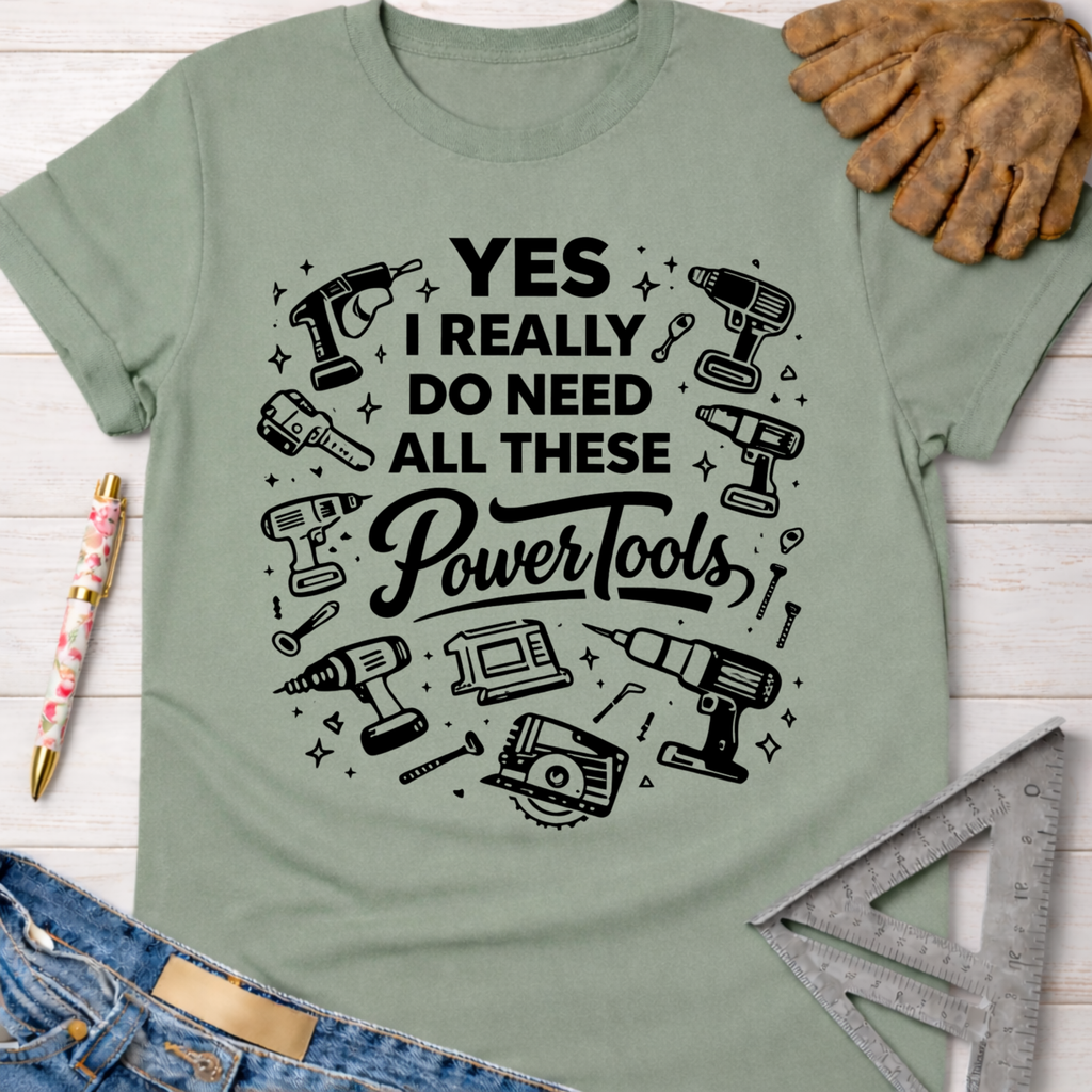 Women's funny woodworking graphic tee shirt for female woodworkers, makers, and DIY builders — Sawdust & Ponytails. Sage green cotton t-shirt with "YES I REALLY DO NEED ALL THESE Power Tools" graphic.