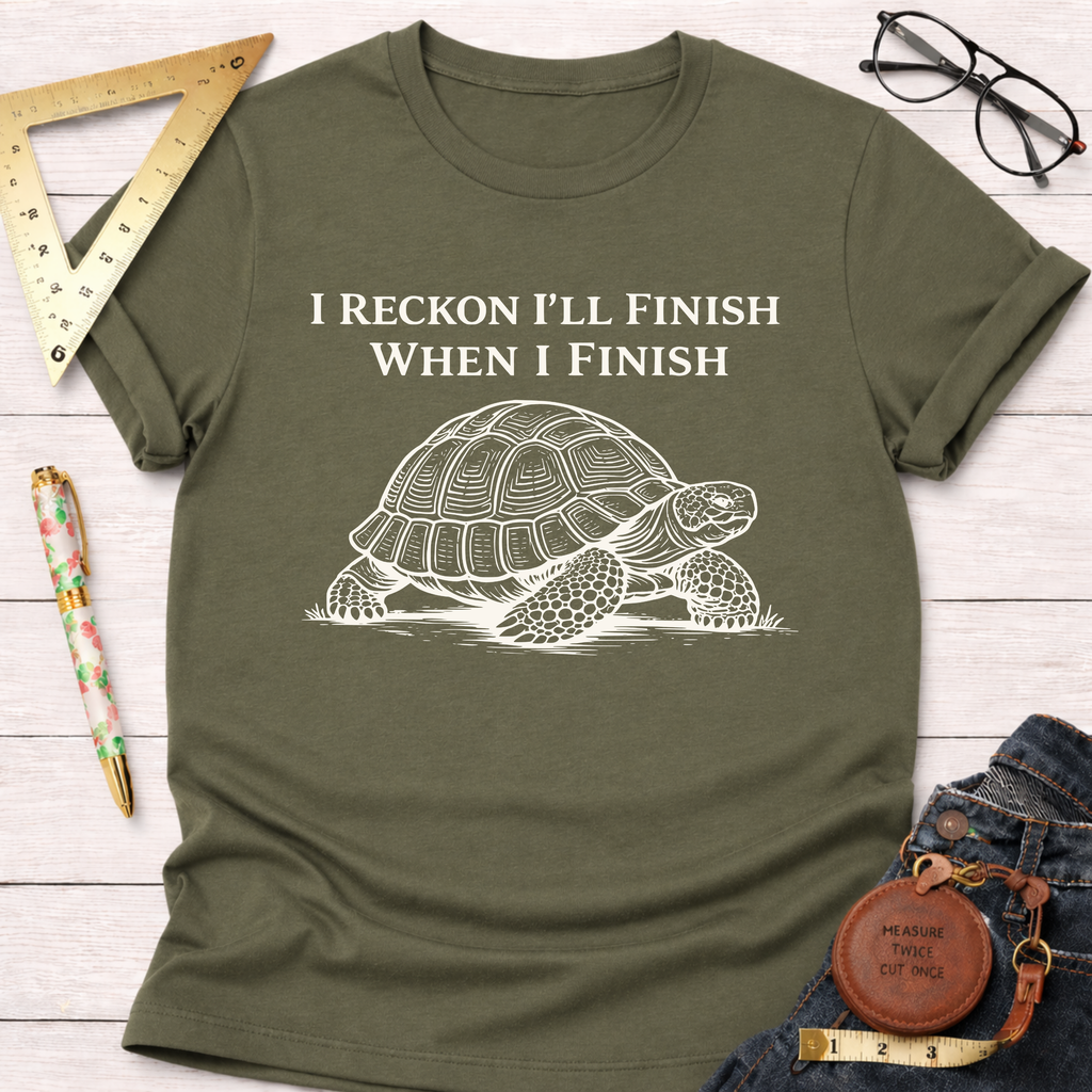 Women's funny woodworking graphic tee shirt for female woodworkers, makers, and DIY builders — Sawdust & Ponytails. Olive green cotton tee with "I Reckon I'll Finish When I Finish" and a white turtle graphic.