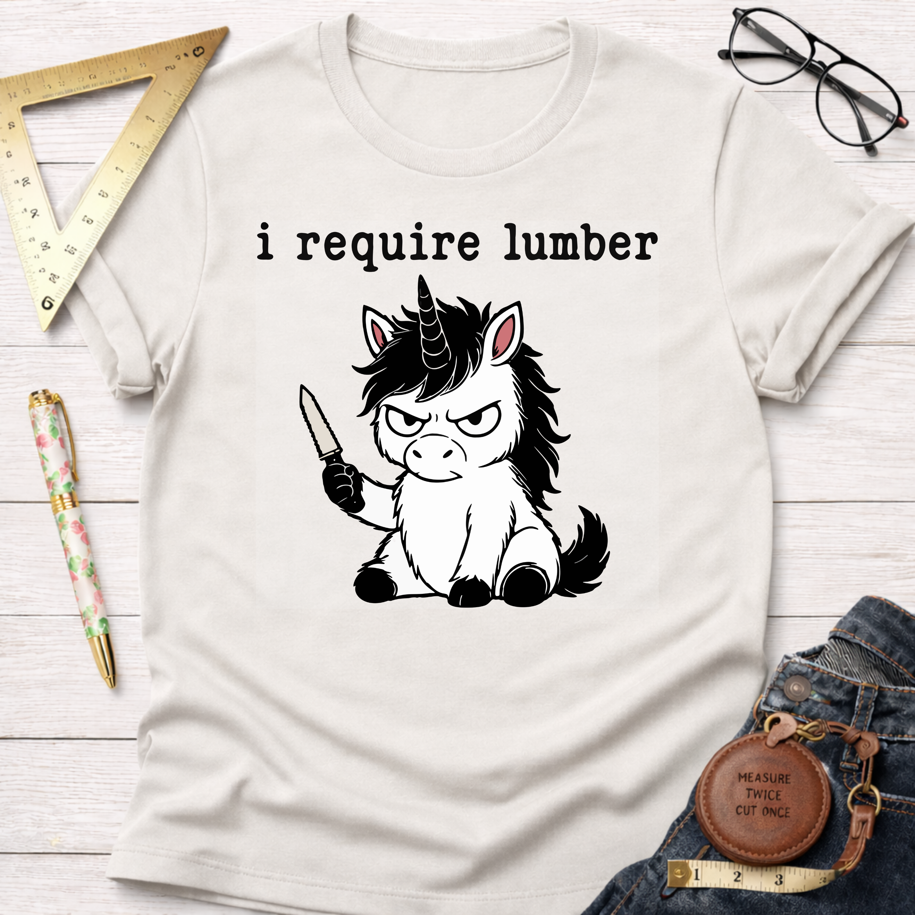 White cotton t-shirt with "i require lumber" text and an angry unicorn holding a knife.