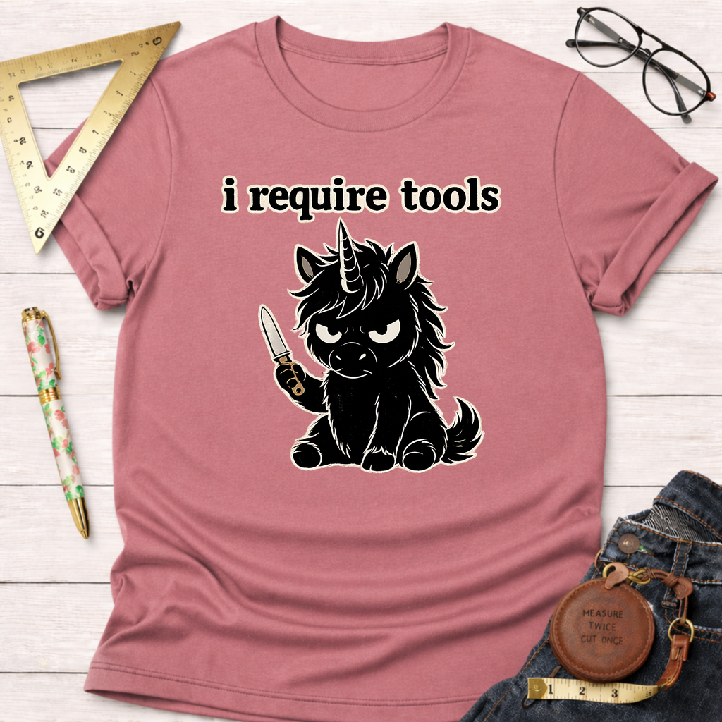 Pink t-shirt with an angry black unicorn holding a knife and "i require tools" text.