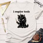 White cotton t-shirt with "i require tools" text and an angry black unicorn holding a knife.