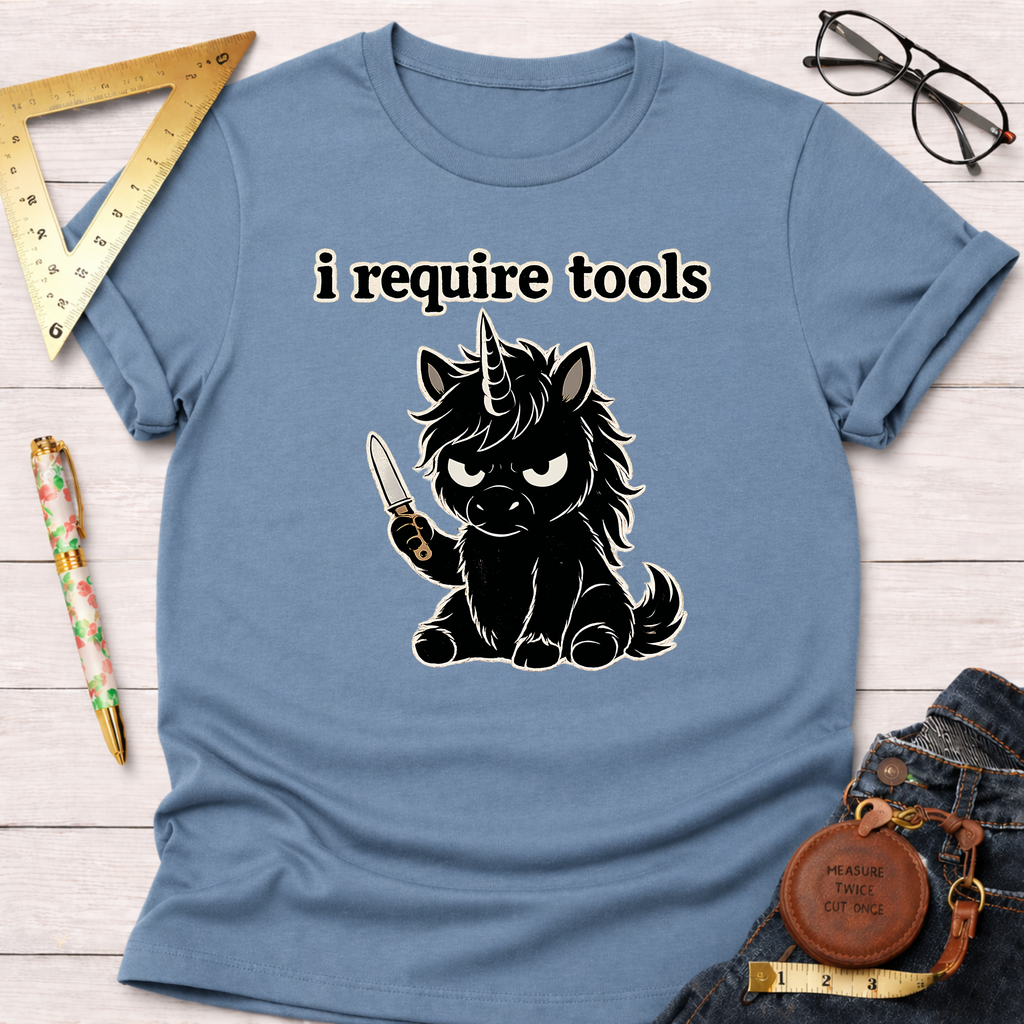 Light blue t-shirt with a black angry unicorn holding a knife and "i require tools" text.