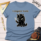 Light blue t-shirt with a black angry unicorn holding a knife and "i require tools" text.