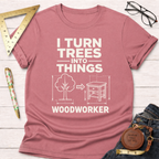Pink "I Turn Trees Into Things Woodworker" graphic t-shirt with a tree and furniture design.