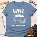 Light blue "I Turn Trees Into Things Woodworker" graphic t-shirt with a tree transforming into a nightstand design.
