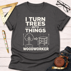 Dark gray cotton t-shirt with "I Turn Trees Into Things Woodworker" graphic and a tree transforming into a table.