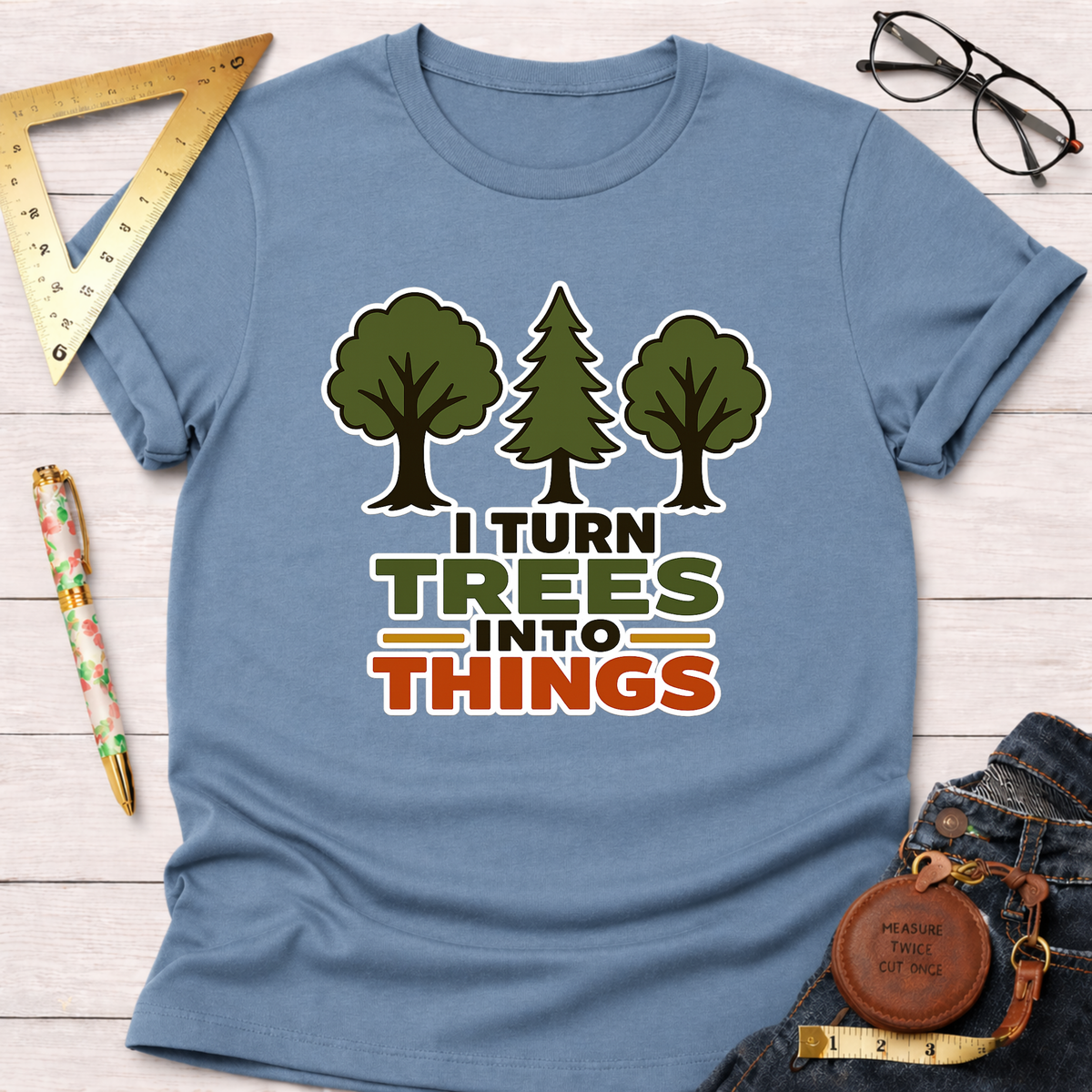 Light blue cotton t-shirt with "I Turn Trees Into Things" graphic and three tree illustrations.