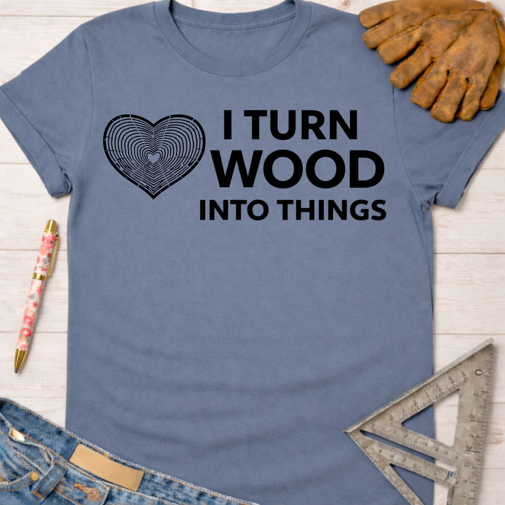 Women's funny woodworking graphic tee shirt for female woodworkers, makers, and DIY builders — Sawdust & Ponytails. Blue cotton tee with "I Turn Wood Into Things" text and a heart-shaped wood grain graphic.