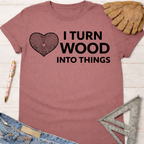 Women's funny woodworking graphic tee shirt for female woodworkers, makers, and DIY builders — Sawdust & Ponytails. Mauve t-shirt with "I Turn Wood Into Things" text and a heart-shaped wood grain graphic.