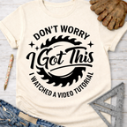 Women's funny woodworking graphic tee shirt for female woodworkers, makers, and DIY builders — Sawdust & Ponytails. Cream t-shirt with "Don't Worry I Got This I Watched A Video Tutorial" text and saw blade graphic.