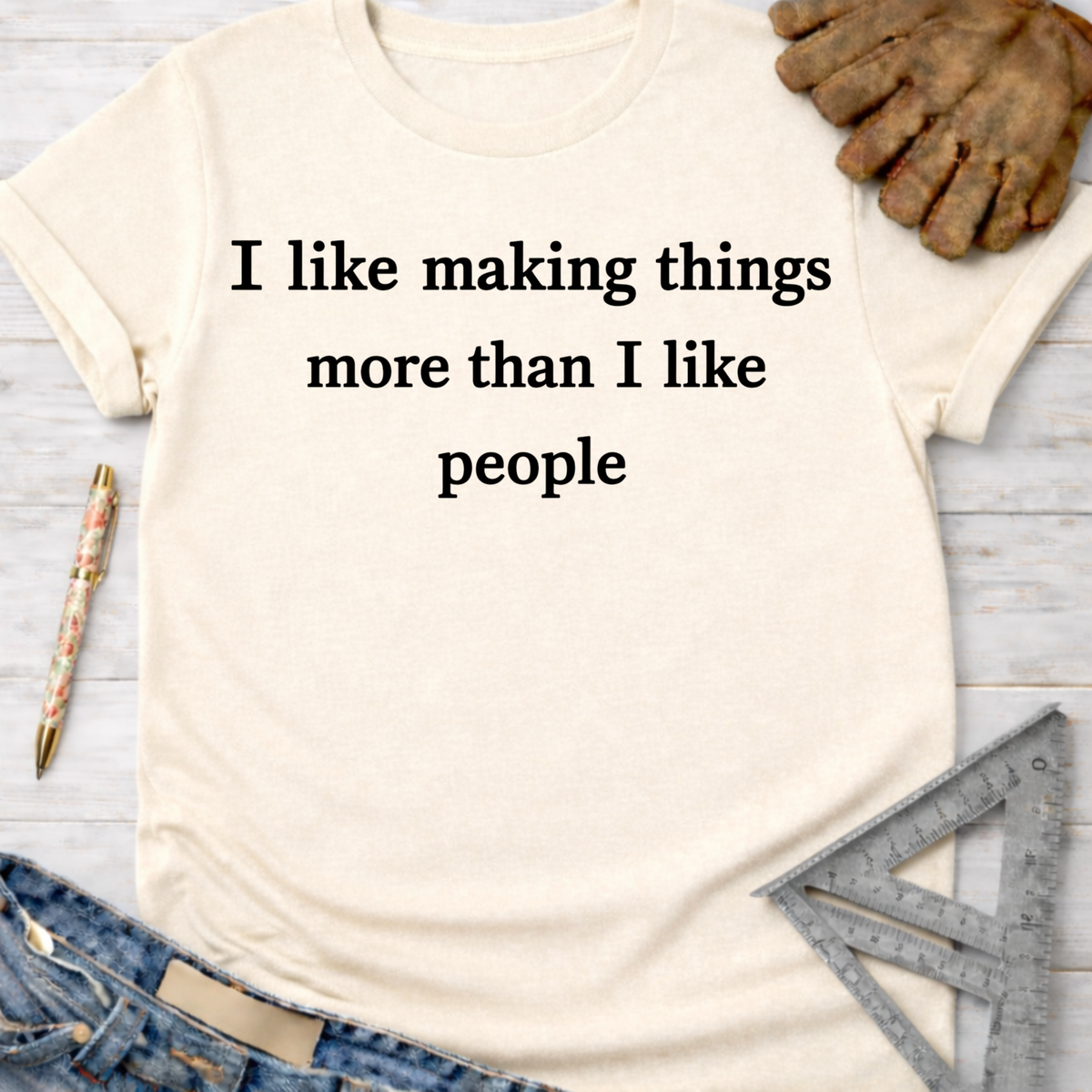 Women's funny woodworking graphic tee shirt for female woodworkers, makers, and DIY builders — Sawdust & Ponytails. Cream t-shirt with "I like making things more than I like people" text.