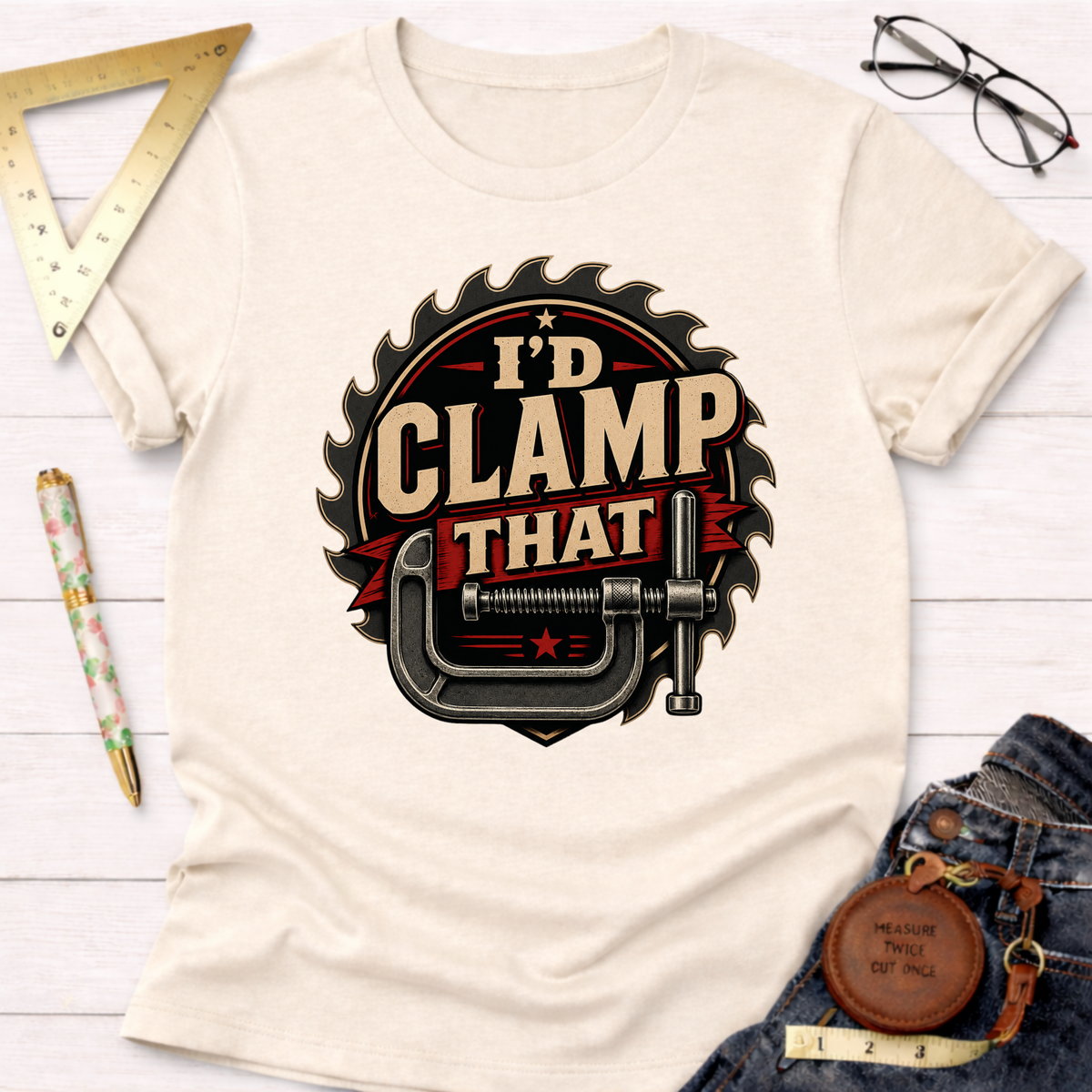Cream "I'd Clamp That" t-shirt with a saw blade and clamp graphic.
