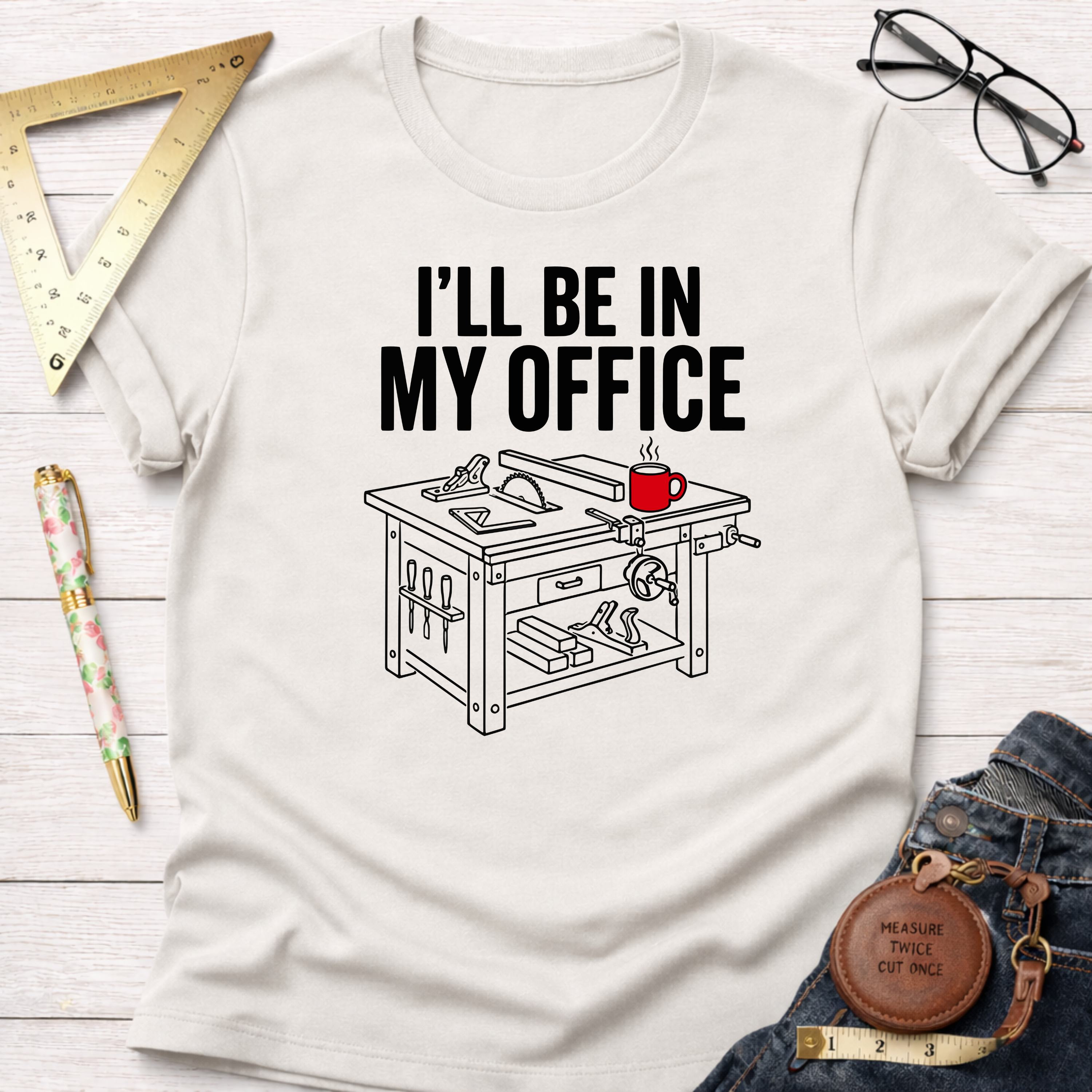 Cream cotton t-shirt with "I'll Be In My Office" text and a woodworking table saw graphic with a red coffee mug.
