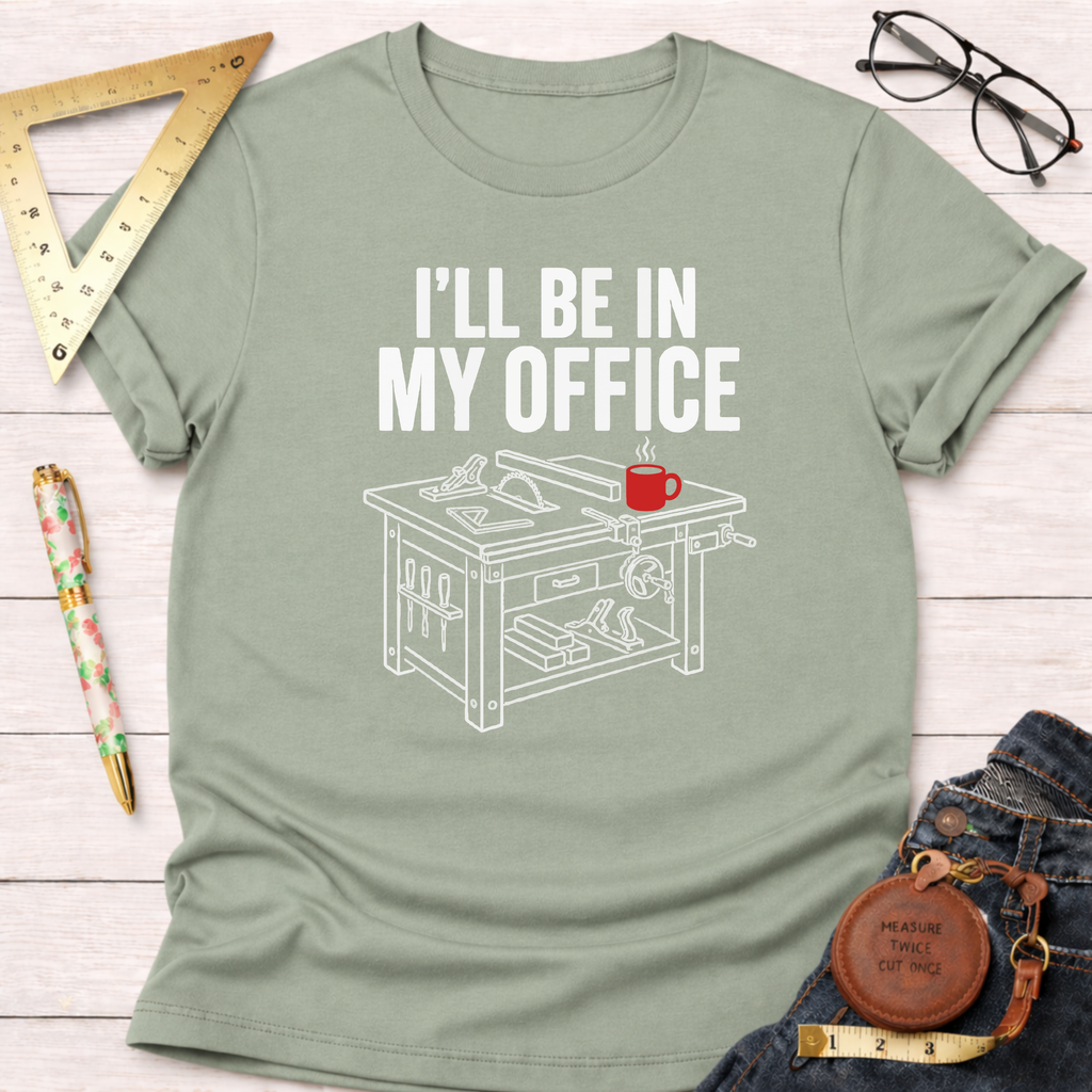 Sage green cotton t-shirt with "I'll Be In My Office" text and a woodworking saw table graphic.
