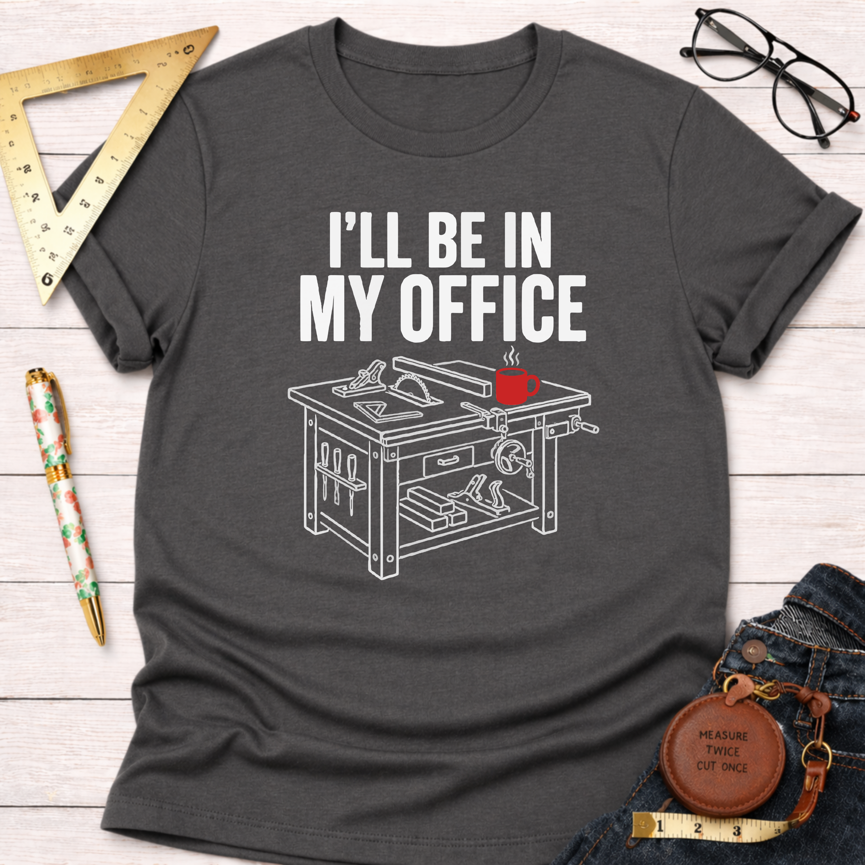 Dark gray cotton t-shirt with "I'LL BE IN MY OFFICE" text and a white line art saw table design with a red coffee mug.
