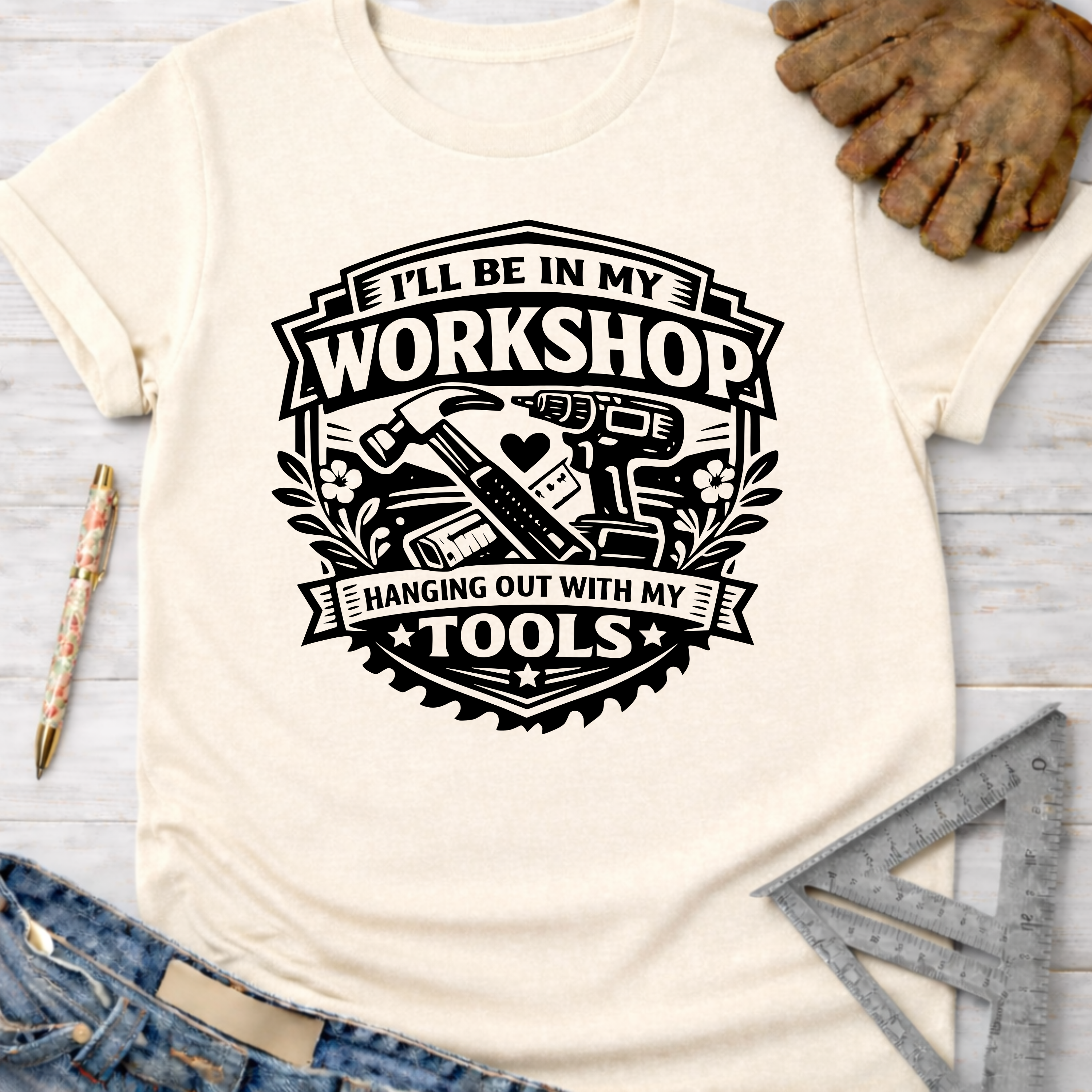 Women's funny woodworking graphic tee shirt for female woodworkers, makers, and DIY builders — Sawdust & Ponytails. Cream t-shirt with "I'll Be In My Workshop Hanging Out With My Tools" graphic featuring hammer, drill, and saw.