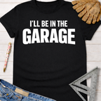 Black cotton "I'll Be In The GARAGE" graphic tee, with work gloves, jeans, and a ruler. Women's funny woodworking graphic tee shirt for female woodworkers, makers, and DIY builders — Sawdust & Ponytails