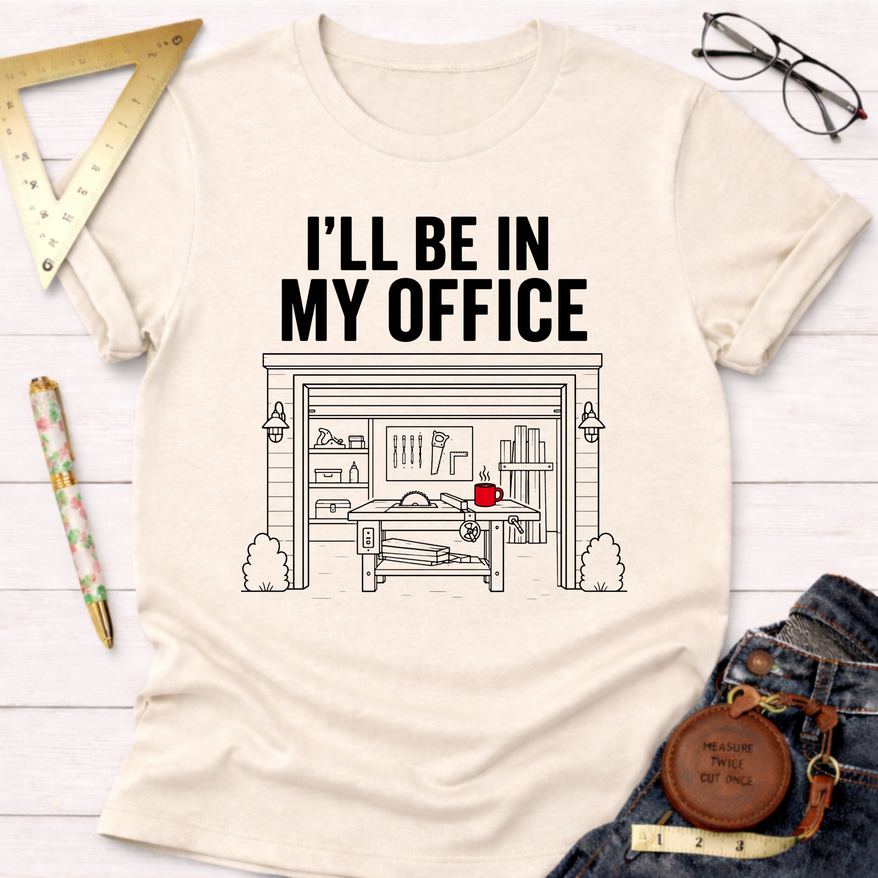 Cream t-shirt with "I'LL BE IN MY OFFICE" text above a detailed garage workshop illustration.