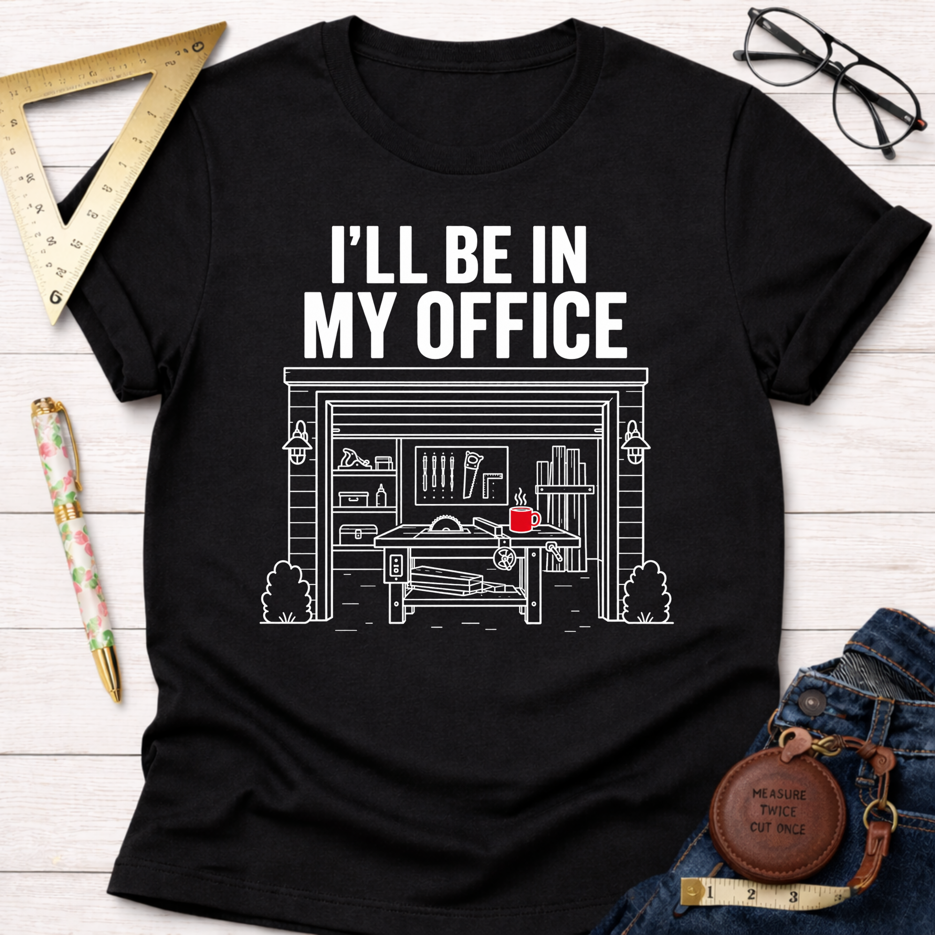 Black cotton t-shirt with "I'LL BE IN MY OFFICE" text and a detailed garage workshop illustration.