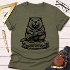 Women's funny woodworking graphic tee shirt for female woodworkers, makers, and DIY builders — Sawdust & Ponytails. Olive green cotton tee with a black beaver holding wood on a tree stump, "I'M GOOD WITH WOOD" text.