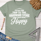 Women's funny woodworking graphic tee shirt for female woodworkers, makers, and DIY builders — Sawdust & Ponytails. Sage green cotton tee with "I'm Just One Trip To The Hardware Store Away From Being Happy" in white text.