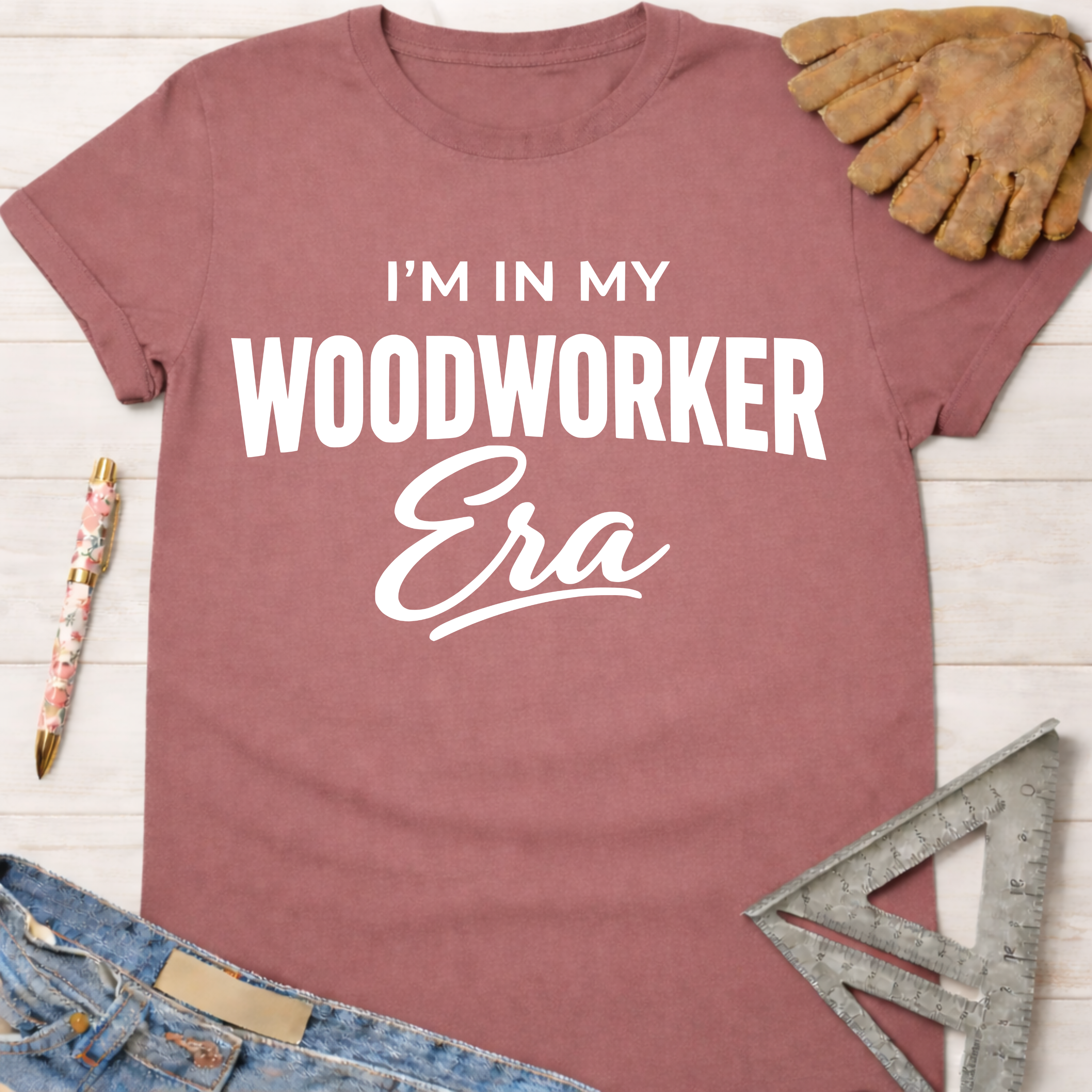 Women's funny woodworking graphic tee shirt for female woodworkers, makers, and DIY builders — Sawdust & Ponytails. Mauve short-sleeve tee with "I'm in My Woodworker Era" in white text.