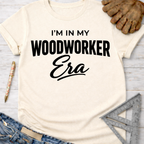 Women's funny woodworking graphic tee shirt for female woodworkers, makers, and DIY builders — Sawdust & Ponytails. Cream t-shirt with "I'm In My Woodworker Era" in black text.