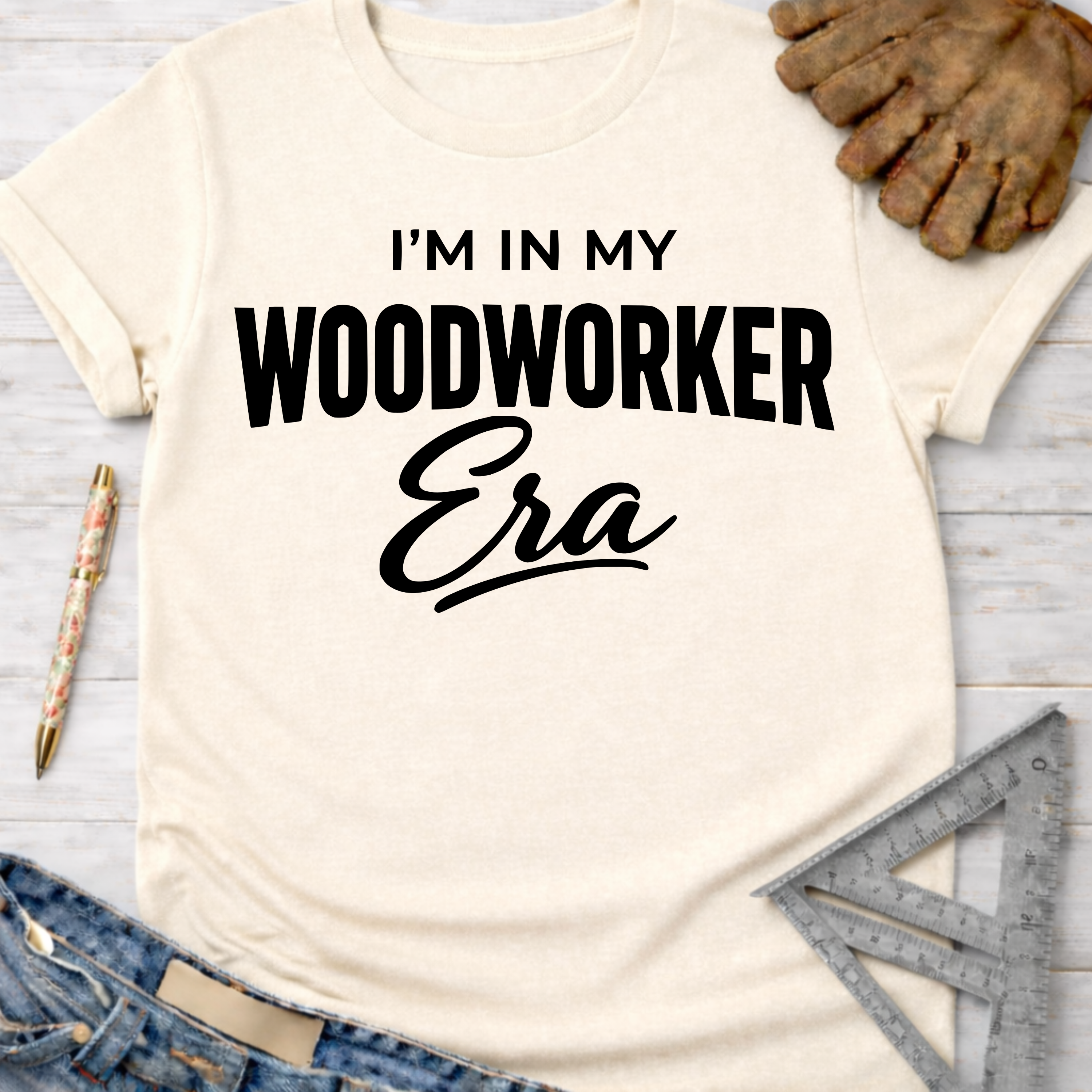 Women's funny woodworking graphic tee shirt for female woodworkers, makers, and DIY builders — Sawdust & Ponytails. Cream t-shirt with "I'm In My Woodworker Era" in black text.