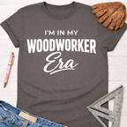 Women's funny woodworking graphic tee shirt for female woodworkers, makers, and DIY builders — Sawdust & Ponytails. Dark gray cotton tee with "I'm In My Woodworker Era" in white text.