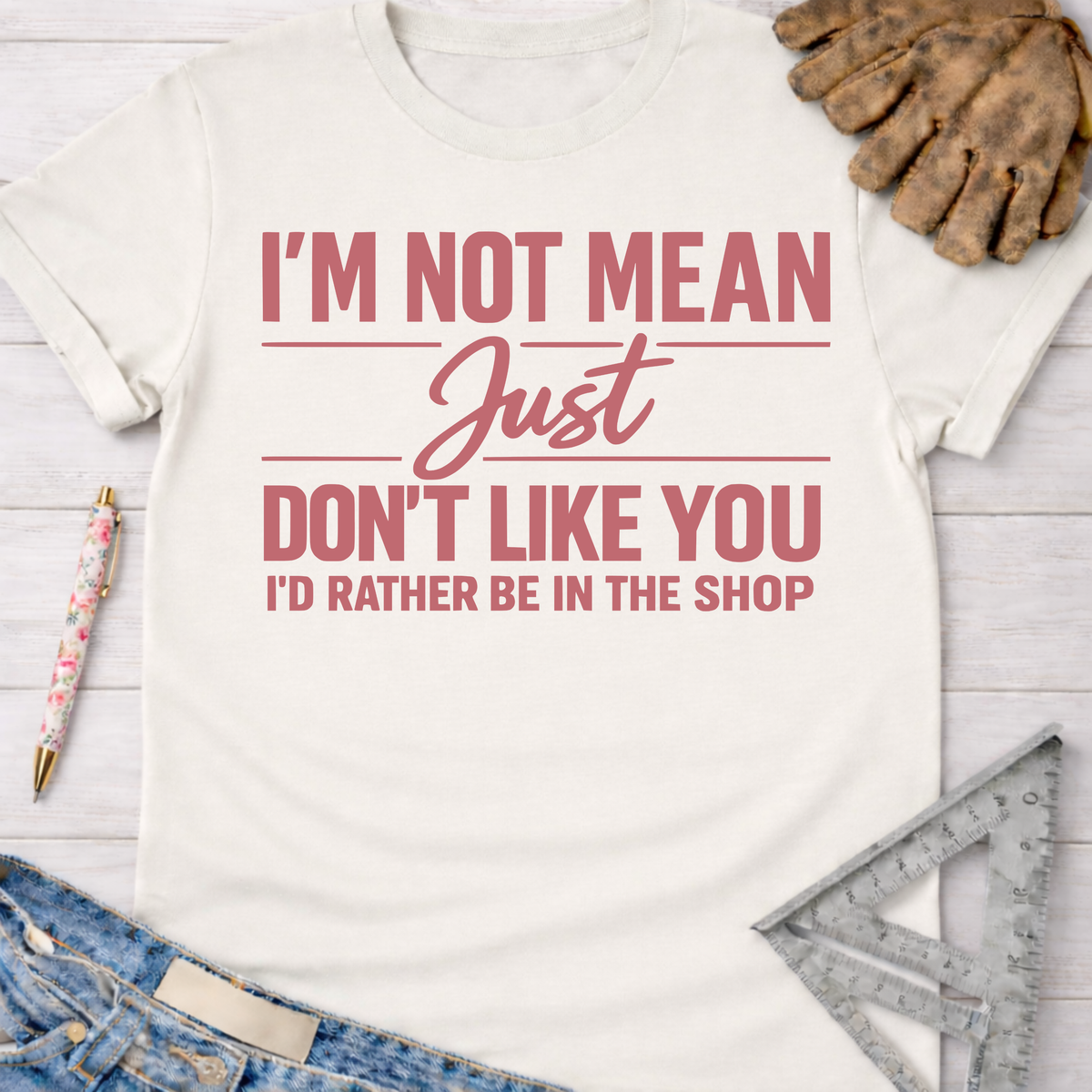 Women's funny woodworking graphic tee shirt for female woodworkers, makers, and DIY builders — Sawdust & Ponytails. White cotton tee with "I'm Not Mean Just Don't Like You I'd Rather Be In The Shop" in pink text.