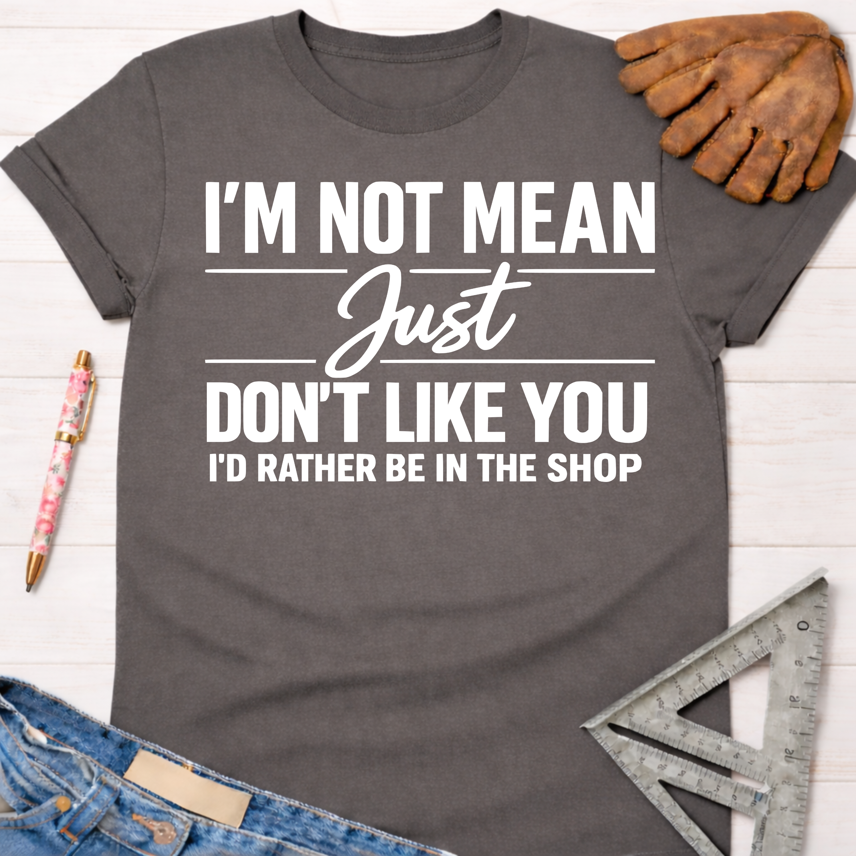 Women's funny woodworking graphic tee shirt for female woodworkers, makers, and DIY builders — Sawdust & Ponytails. Dark gray cotton tee with "I'm Not Mean Just Don't Like You I'd Rather Be In The Shop" in white text.