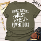 Olive green "No Instructions Just Vibes And Power Tools" t-shirt with white text, flat lay.