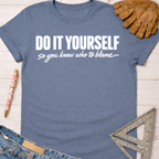 Women's funny woodworking graphic tee shirt for female woodworkers, makers, and DIY builders — Sawdust & Ponytails. Blue short-sleeve tee with "DO IT YOURSELF so you know who to blame" in white text.