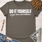 Women's funny woodworking graphic tee shirt for female woodworkers, makers, and DIY builders — Sawdust & Ponytails. Dark gray cotton t-shirt with "DO IT YOURSELF so you know who to blame" in white text.