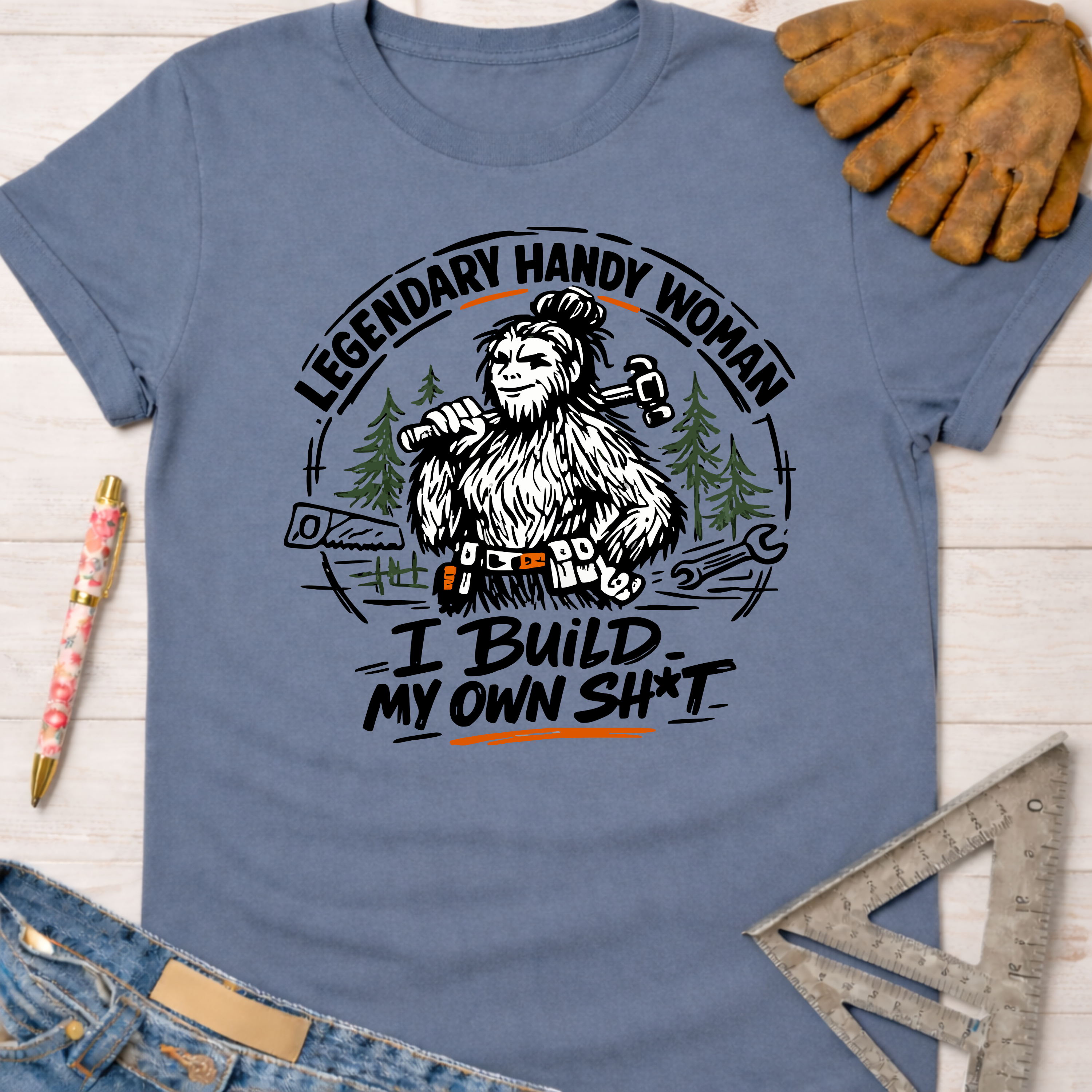 Women's funny woodworking graphic tee shirt for female woodworkers, makers, and DIY builders — Sawdust & Ponytails. Blue cotton tee with "Legendary Handy Woman" Bigfoot graphic.