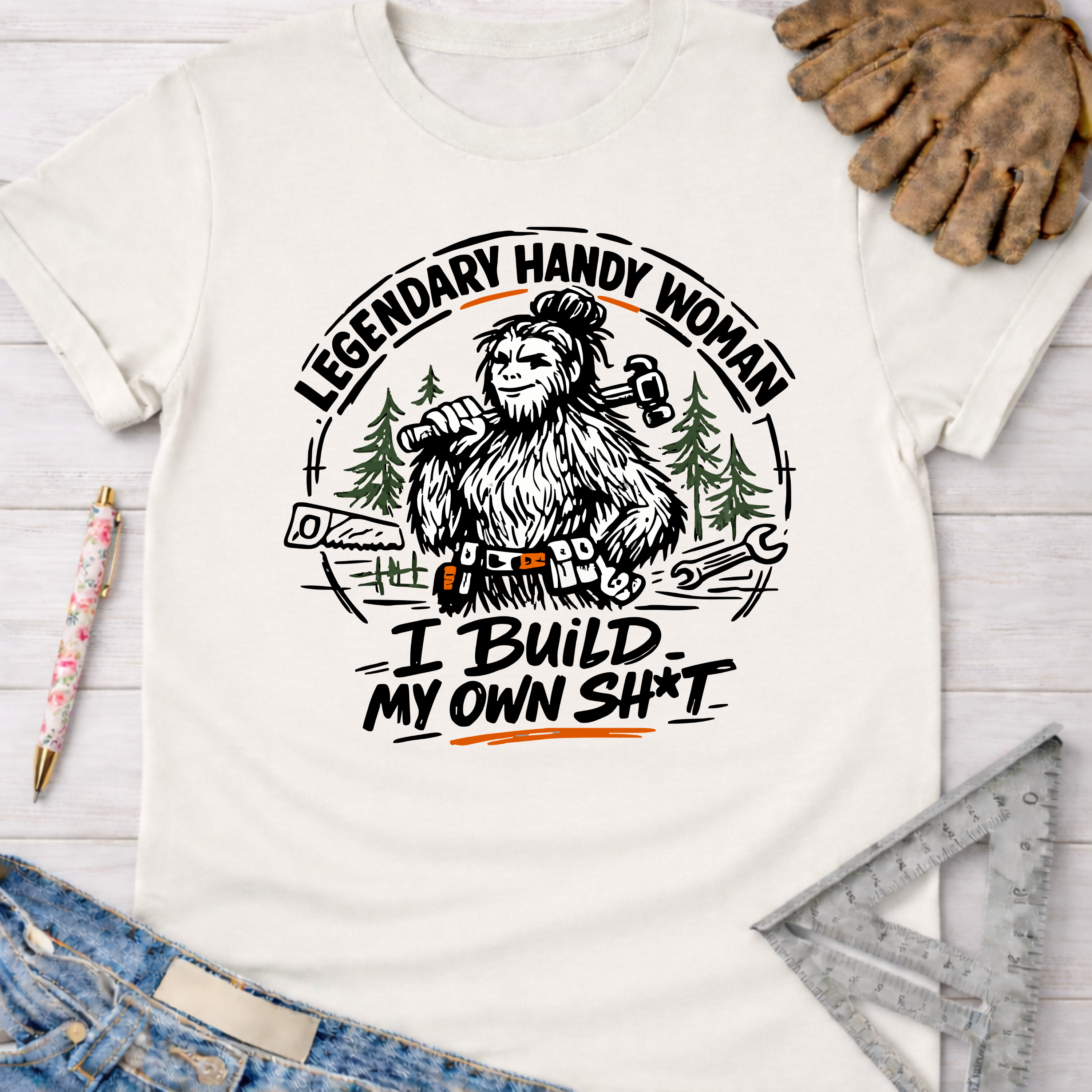 Women's funny woodworking graphic tee shirt for female woodworkers, makers, and DIY builders — Sawdust & Ponytails. White cotton tee with "Legendary Handy Woman" Bigfoot graphic.