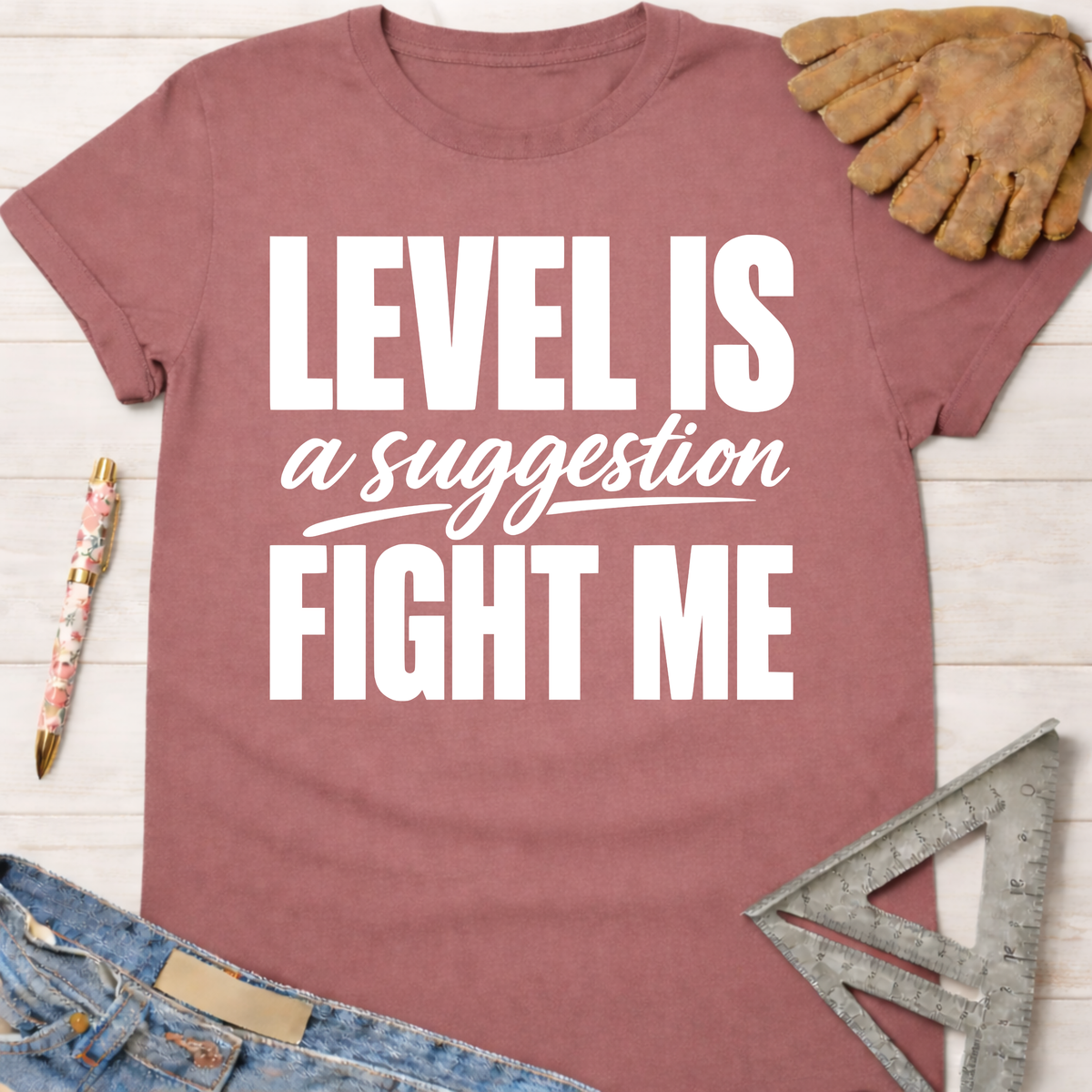 Women's funny woodworking graphic tee shirt for female woodworkers, makers, and DIY builders — Sawdust & Ponytails. Mauve cotton t-shirt with "LEVEL IS a suggestion FIGHT ME" in white text.