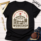 Black cotton tee with "Life Is Good In The Workshop" graphic, tools, and "Measure Twice, Cut Once." Women's funny woodworking graphic tee shirt for female woodworkers, makers, and DIY builders — Sawdust & Ponytails.