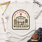 Women's funny woodworking graphic tee shirt for female woodworkers, makers, and DIY builders — Sawdust & Ponytails. Cream cotton tee with "Life Is Good In The Workshop" graphic.