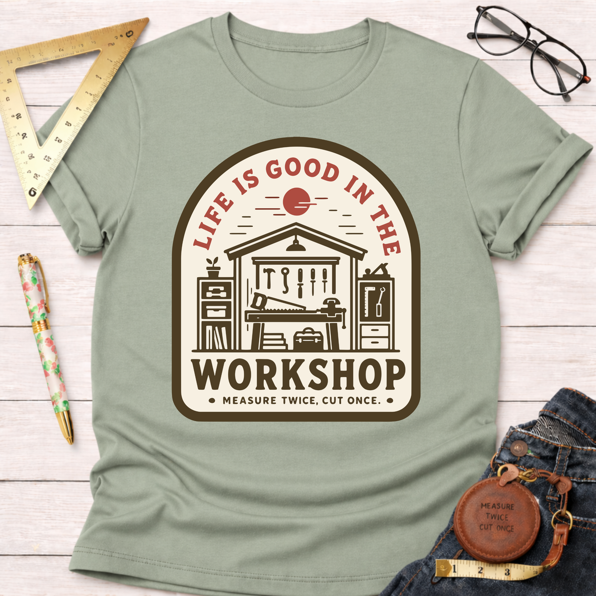 Women's funny woodworking graphic tee shirt for female woodworkers, makers, and DIY builders — Sawdust & Ponytails. Light green cotton tee with "Life Is Good In The Workshop" graphic.