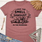 Women's funny woodworking graphic tee shirt for female woodworkers, makers, and DIY builders — Sawdust & Ponytails. Mauve short-sleeve cotton t-shirt with "I Love The Smell of Sawdust In The Morning" graphic.