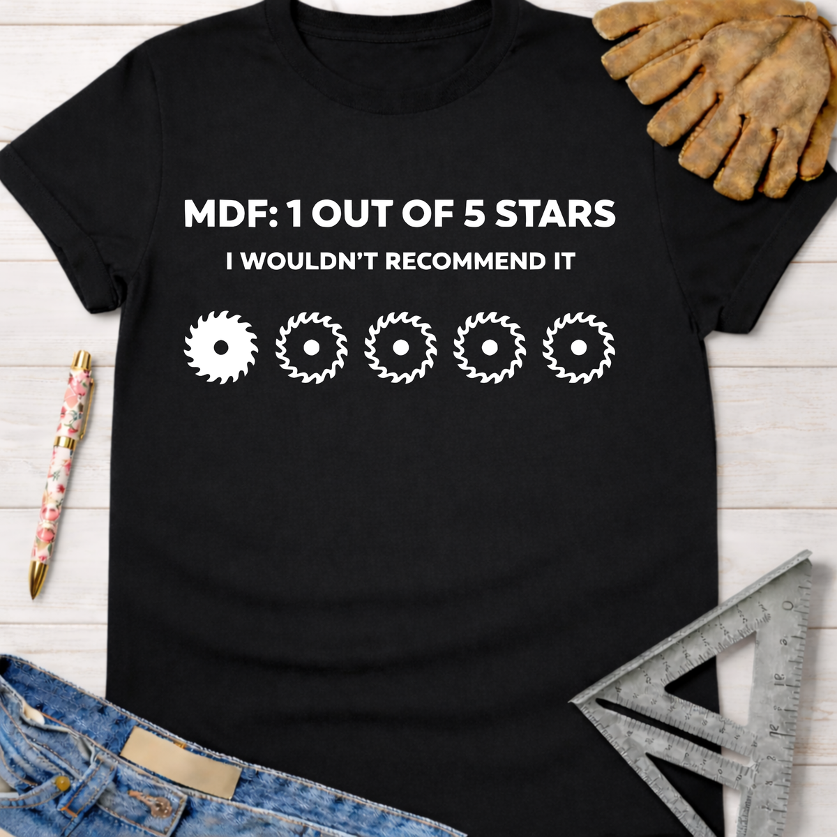 Women's funny woodworking graphic tee shirt for female woodworkers, makers, and DIY builders — Sawdust & Ponytails. Black t-shirt with "MDF: 1 OUT OF 5 STARS I WOULDN'T RECOMMEND IT" and five saw blade graphics.