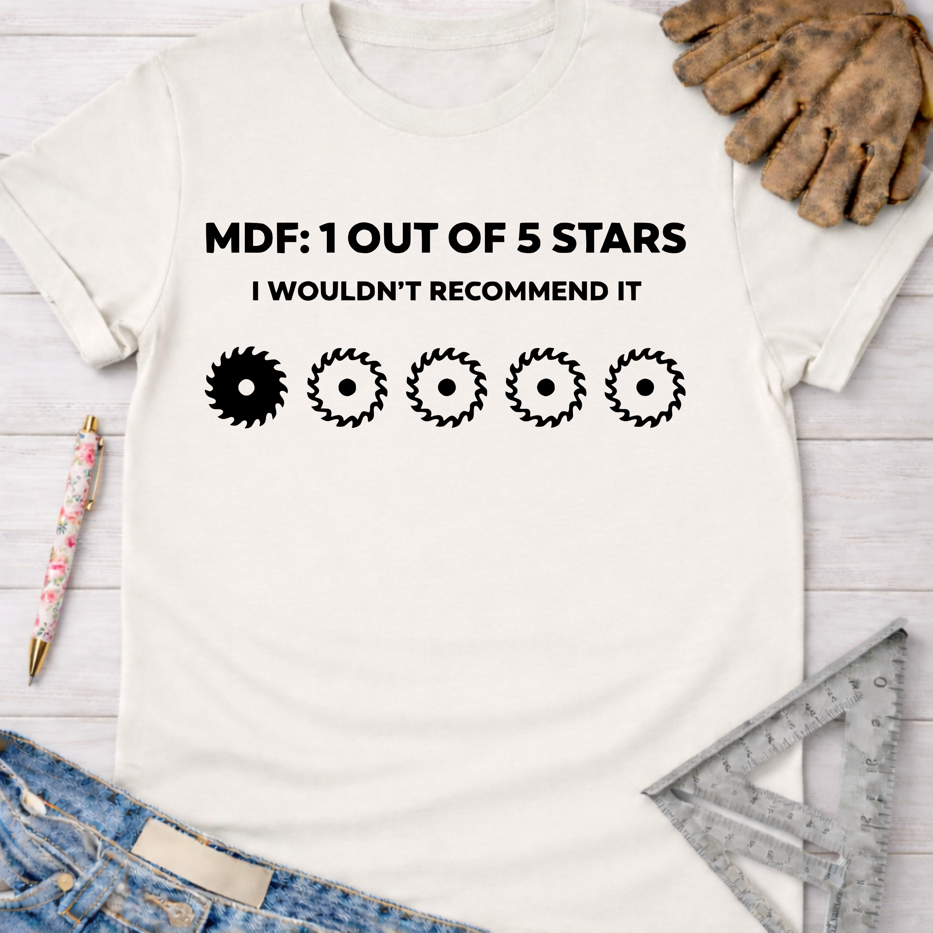 Women's funny woodworking graphic tee shirt for female woodworkers, makers, and DIY builders — Sawdust & Ponytails. White cotton t-shirt with "MDF: 1 OUT OF 5 STARS I WOULDN'T RECOMMEND IT" and five saw blade graphics.