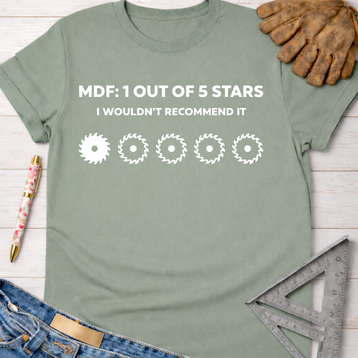 Women's funny woodworking graphic tee shirt for female woodworkers, makers, and DIY builders — Sawdust & Ponytails. Sage green t-shirt with "MDF: 1 OUT OF 5 STARS I WOULDN'T RECOMMEND IT" and four saw blade graphics.