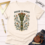 Cream cotton "Made To Make" t-shirt with a colorful, ornate paint brush and floral design.