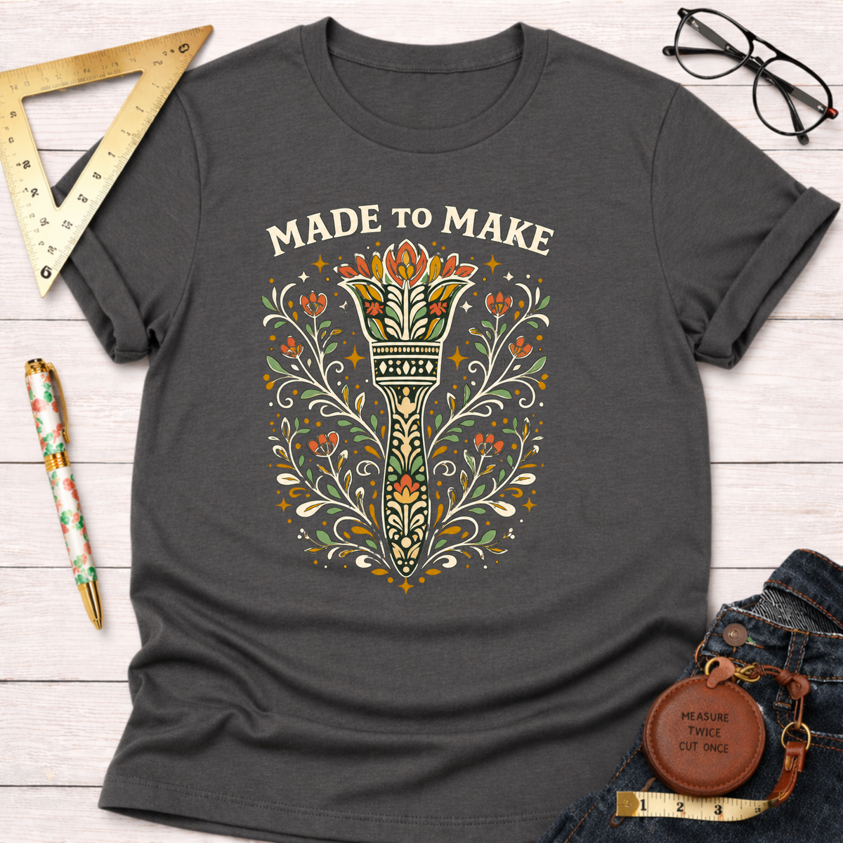 Charcoal gray cotton t-shirt with "Made To Make" text and a colorful, ornate paint brush design.