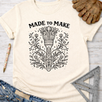 Women's funny woodworking graphic tee shirt for female woodworkers, makers, and DIY builders — Sawdust & Ponytails. Cream t-shirt with "MADE TO MAKE" and ornate floral torch design.